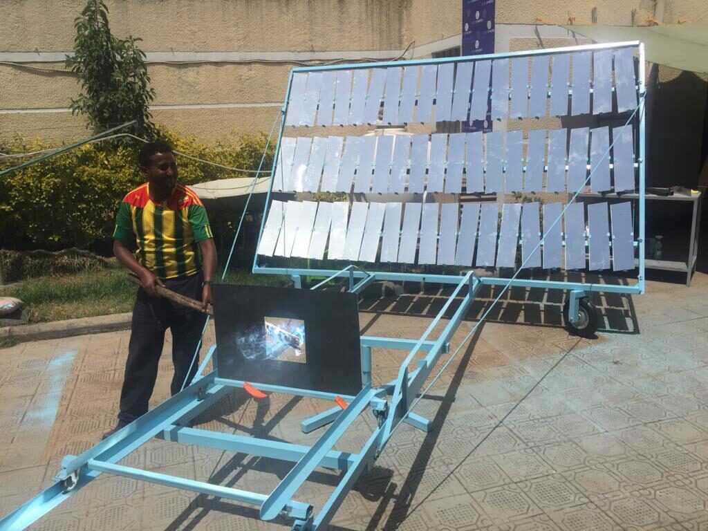 A man standing next to a solar panel.