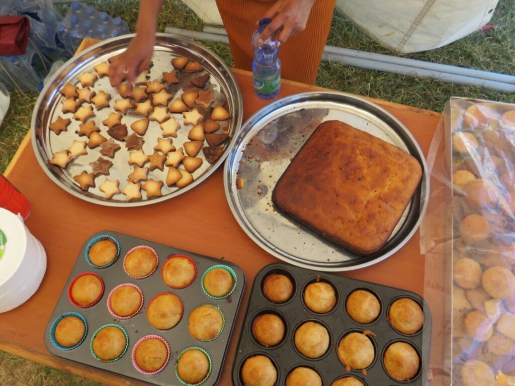 A table with two pans of muffins and one pan of cake.